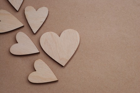 Valentines day background with Laser Cut Wooden Hearts on Neutral Craft Paper Background with Copy Paste. Rustic Love Background.の写真素材