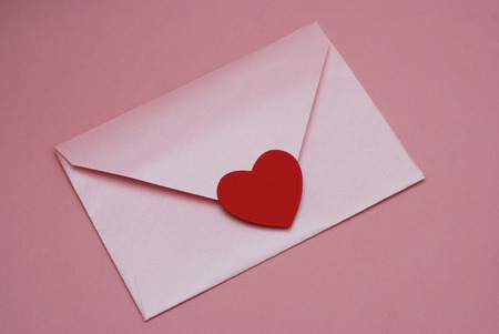 Valentines or Mother Woman day. Background with Pink Envelope with Red Paper Heart, on Pink Background.の写真素材