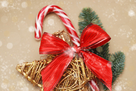 Holiday background image of peppermint candy sticks with Red Bow and golden Decorative Star and Fir Branches on background. Christmas Background.の写真素材