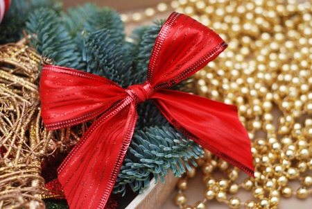 Closeup of Red Bow Christmas Arrangement with Golden Beads defocused abstract light background.の写真素材