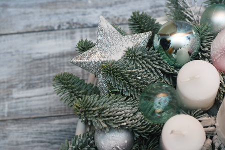Christmas arrangement with pine twigs, cones and silver star isolated on gray wooden backgroundの写真素材