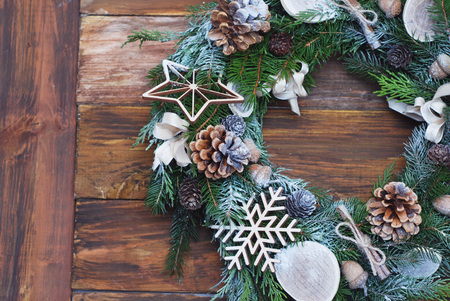 Christmas wreath of Fir branches, cones,natural decorations on dark wooden background. Xmas and Happy New Year composition. Flat lay, top viewの写真素材