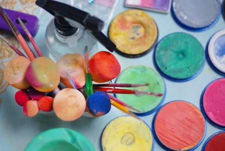 Colorful paint tubes on a table with paints used for face art. Top View.の写真素材