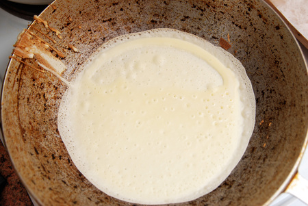Raw pancake in a old vintage frying pan on a dark backgroundの写真素材