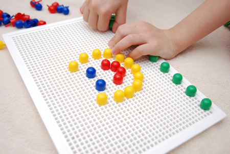 Childrens hands playing with mozaic creative game, close up, Childhood, play, education, learning, developmentの写真素材