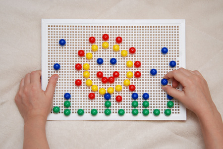 Children mosaic, a game for creativity. Hands playing with mosaic game. Top view.の写真素材