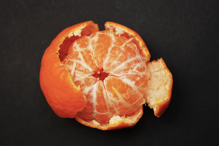 Piled Mandarin on dark table Isolated. Peeled tangerine and shells. Vitamine and Healthy concept.の写真素材