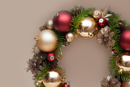 Christmas Decorative Wreath with Fir Branch and Red Globes on Beige background with Copy Space.の写真素材