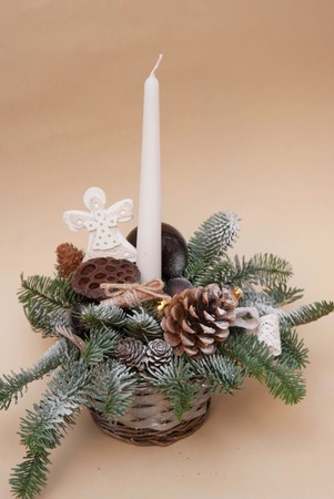 Winter Rustic Composition with Candle in Basket with Natural Wreath, Pinecone, Ornaments. Isoalted. Vertical Image.の写真素材
