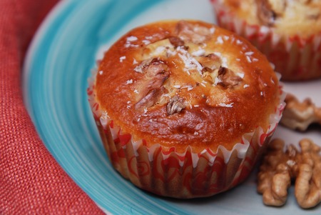 Freshly Baked Cinnamon Spice Muffin Sprinkled with Nuts on Rustic Plate and Orange Napkin.の写真素材