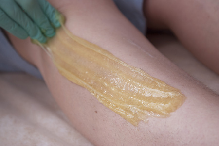 Depilatory Procedure with Sugar Ppaste. Removing Hair on Womens legs. Procedure sugaring in a beauty salon. Sugar depilation.の写真素材