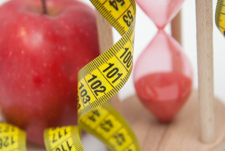 Lose Weight Concept. Red Apple and Tape Measure close up. Fat Burning and Weight loss process.の写真素材