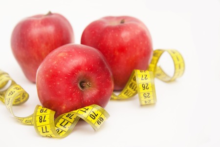 Three Red Apples Isolated on White Background. Fat Burning and Weight loss process. Tape Measure. Copy space.の写真素材