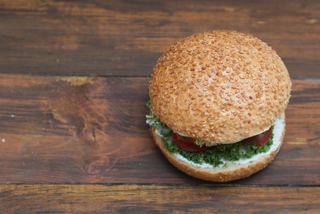 Top view of Homemade Hamburger with Fresh Letuce leaves, tomatoe Slice, Meat. Homemade Healthy Food or Fast food, with fresh Vegetables on rustic Wooden Background with copy Space.の写真素材