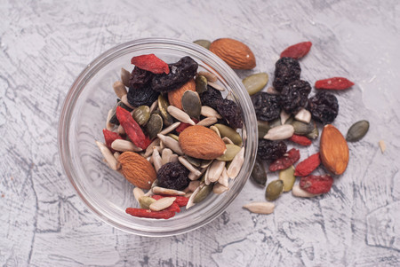 Close up of a Mixed of Nuts, Dry Fruits in glass Bowl on Gray Textured Background.の写真素材