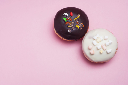 Doughnuts with Chocolate and White Icing on Pastel Pink Background. Sweet Dessert Donutsの写真素材