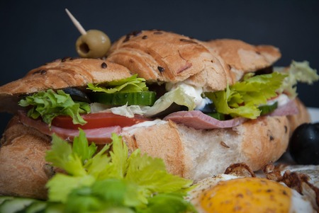 Close Up Croissant Sandwich with Vegetables and Green Oliveの写真素材