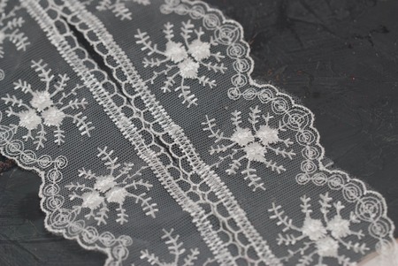 Embroidered Border White Lace on Dark Surface. Lace Texture Background.の写真素材