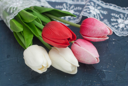 Bouquet of Spring Tulips, White and Red Flowers With Lace over Dark Background.の写真素材
