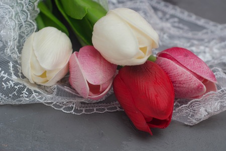 Bouquet of Fake foam Tulips on Gray Cement Background with Laceの写真素材