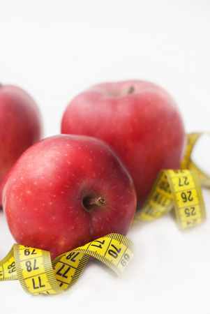 Fat Burning. Looe Weight. Red Apple with Measure Tape for Diet and Fitness with Copy space . Isoalted on White Background.の写真素材