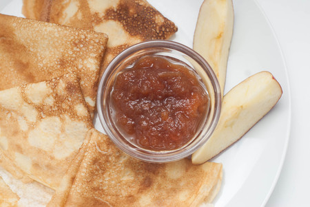Delicious Homemade Thin Pancakes with Apple Jam on White Plate. Breakfast Isolatedの写真素材