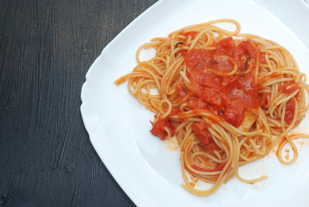 Italian Spagetthi Bolognese with Tomatoes Spiced Sauce in White Plate Isolated on Black board.の写真素材