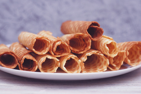 Big stack of homemade crispy waffles. Rolled into a tube. Close Up Cookies Dessert.の写真素材