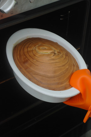 Remove freshly Baked Pie from Oven. Making Zebra Chocolate and Vannilie Pie. Bakery and Confectionarry.の写真素材