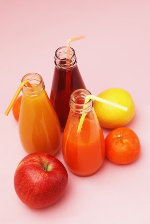 Bottles of Juice over Pink Background. Healthy diet concept. vitamine.の写真素材