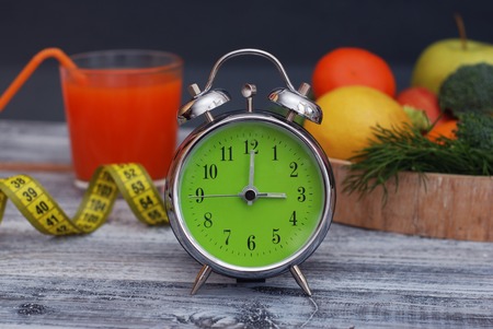 Time to lose Weight. Fruit, Vegetable and glass of juice and Alarm Clock on the table, Diet and Fitness concept.の写真素材