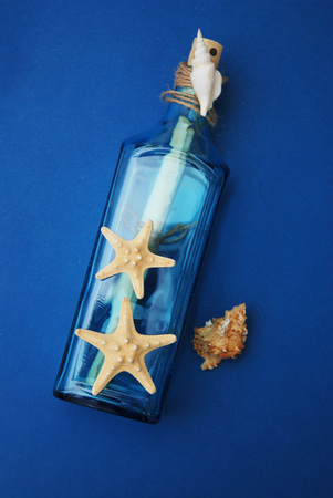 Nautical Theme Backdrop, Decorative Bottle with Shells, Starfish on Depp blue Background.Copy Space.の写真素材