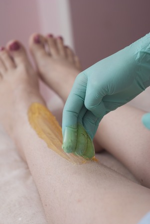 Female legs depilation with sugar pasta. Beauty Cosmetic Procedure for Girls Sugaring.の写真素材