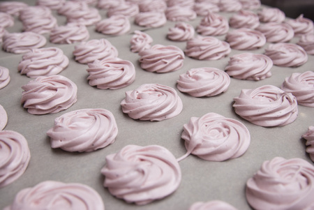 Marshmallow, Meringue, Zephyr over Baking Paper ready for Drying. Pink Dessert with Strawberry.の写真素材