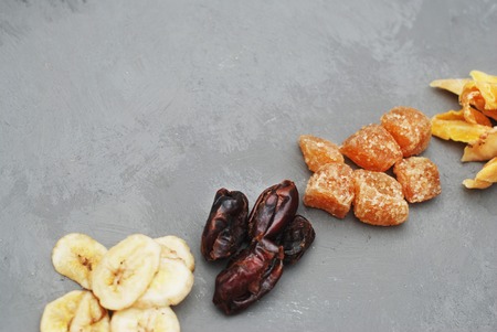 Assortment of Dried Fruits: Banana, Ginger, Mango over Gray Background with copy space. Flat Lay.の写真素材