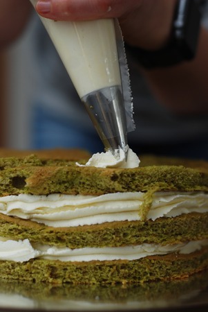 Pastry Bag with White Strawberry Cream Putting Cream Decorations over Cake. Cake cooking Proces. Step by Step.の写真素材