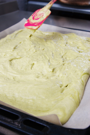 Raw homemade Dough with Green Tea Matcha Pouring over Baking Sheet. Step by Step Dessert Preparing.の写真素材