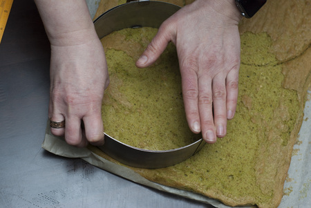 Trimming pastry into round shape. Making Matcha Layer Cake with White Chocolate Cream and Strawberries.の写真素材