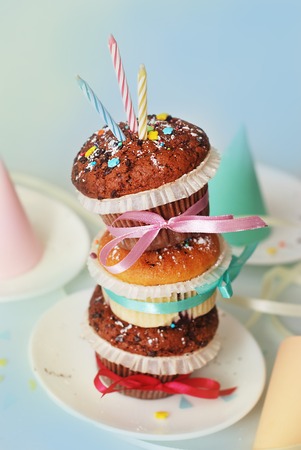 One Birthday Muffin, Cupcake with Candle, on Grey Blue background. Pink bow. Isoalted. Burning Candle.の写真素材
