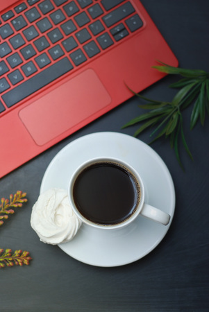 Cup of Coffee and Red Laptop, Tablet, on Black Table. work Place, Office, Desk.の写真素材