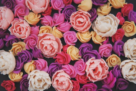 Mix of pink and Peach Fake Plastic Mini rosess Flowers Black Background copy space. Craft, Art,