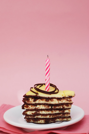 Chocolate Cake on Pink Background with Candle and Copy spaceの写真素材