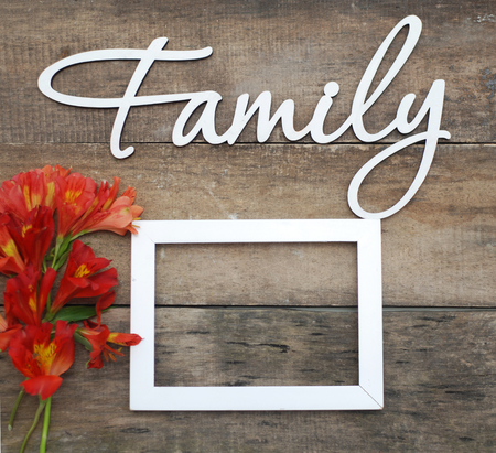 White Wooden Inscription FAMILY Letters Inscription Family Orange Red Alstromeria flowers Rustic Wooden background.の写真素材
