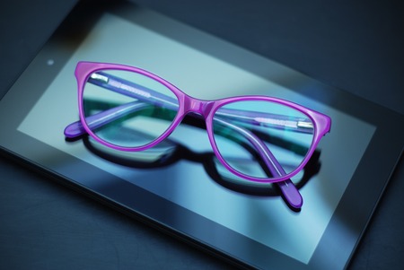 Eyeglasses over Tablet and Mobile Phone over Yellow Background with copy space.の写真素材