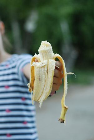 Little Girl Holding Peeled Banana Snack Healthy Food Eatting in the Park Educationalの写真素材