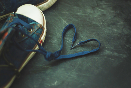 Sport blue Jeans Boots Children Heart Shape Laces over Textured Grounge Chalckboard.の写真素材