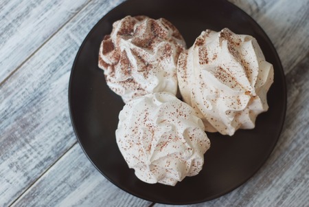 White Meringue Cookies. Sweet Desert over Gray rustic Wooden Boardの写真素材