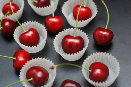 Fresh Cherry Fruit in Cooking Bakery Cupcake Paper. Black Backgroundの写真素材