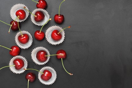 Fresh Cherry Fruit in Cooking Bakery Cupcake Paper. Black Background