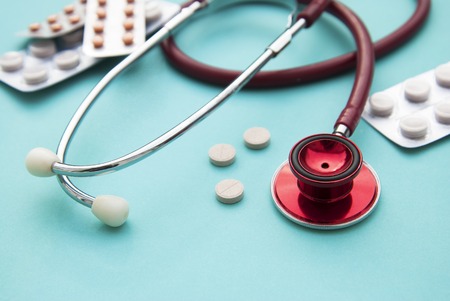 Pills, tablets and sthetoscope on blue background.の写真素材